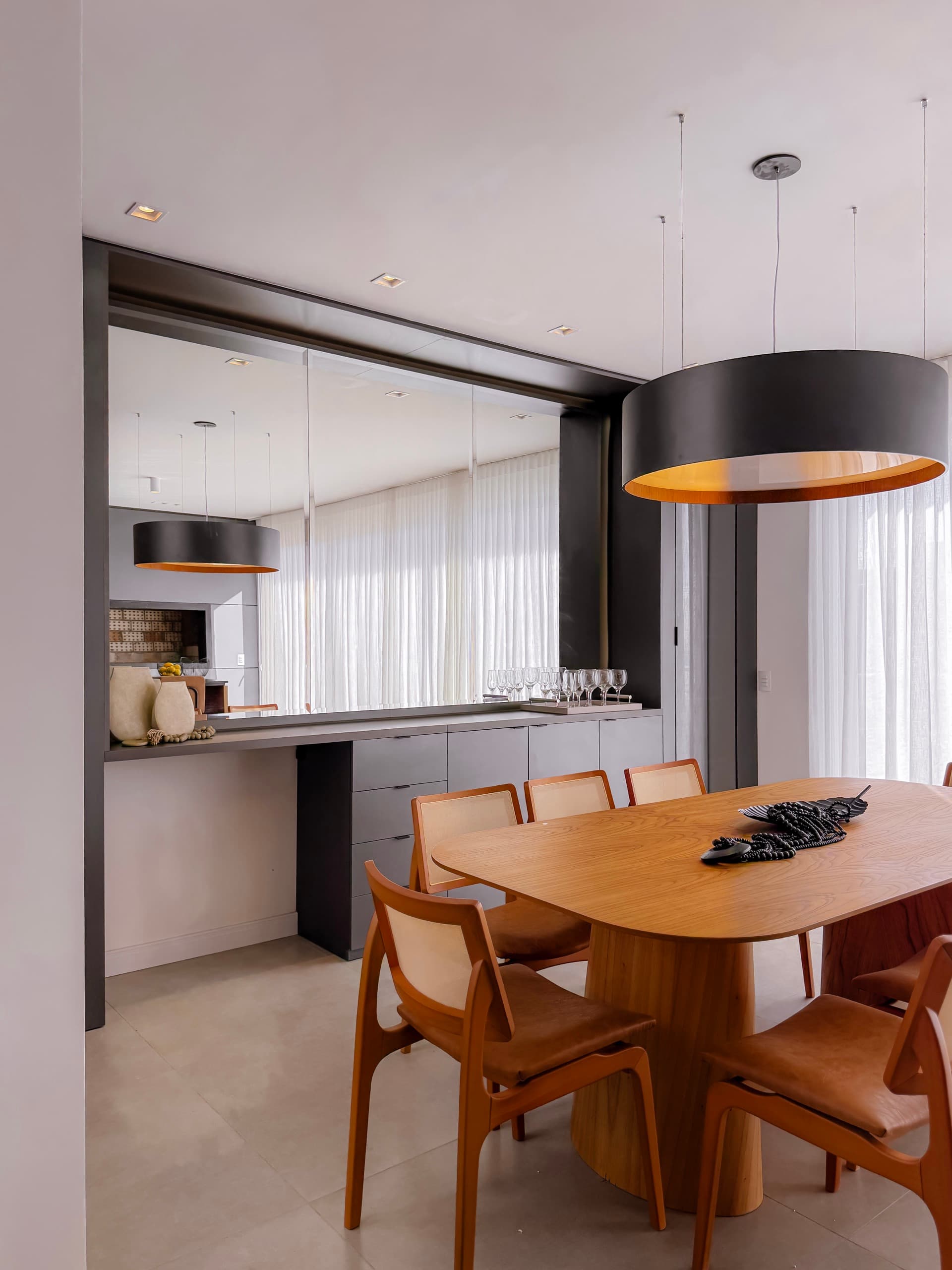Sala de jantar com buffet em grafite sob espelho