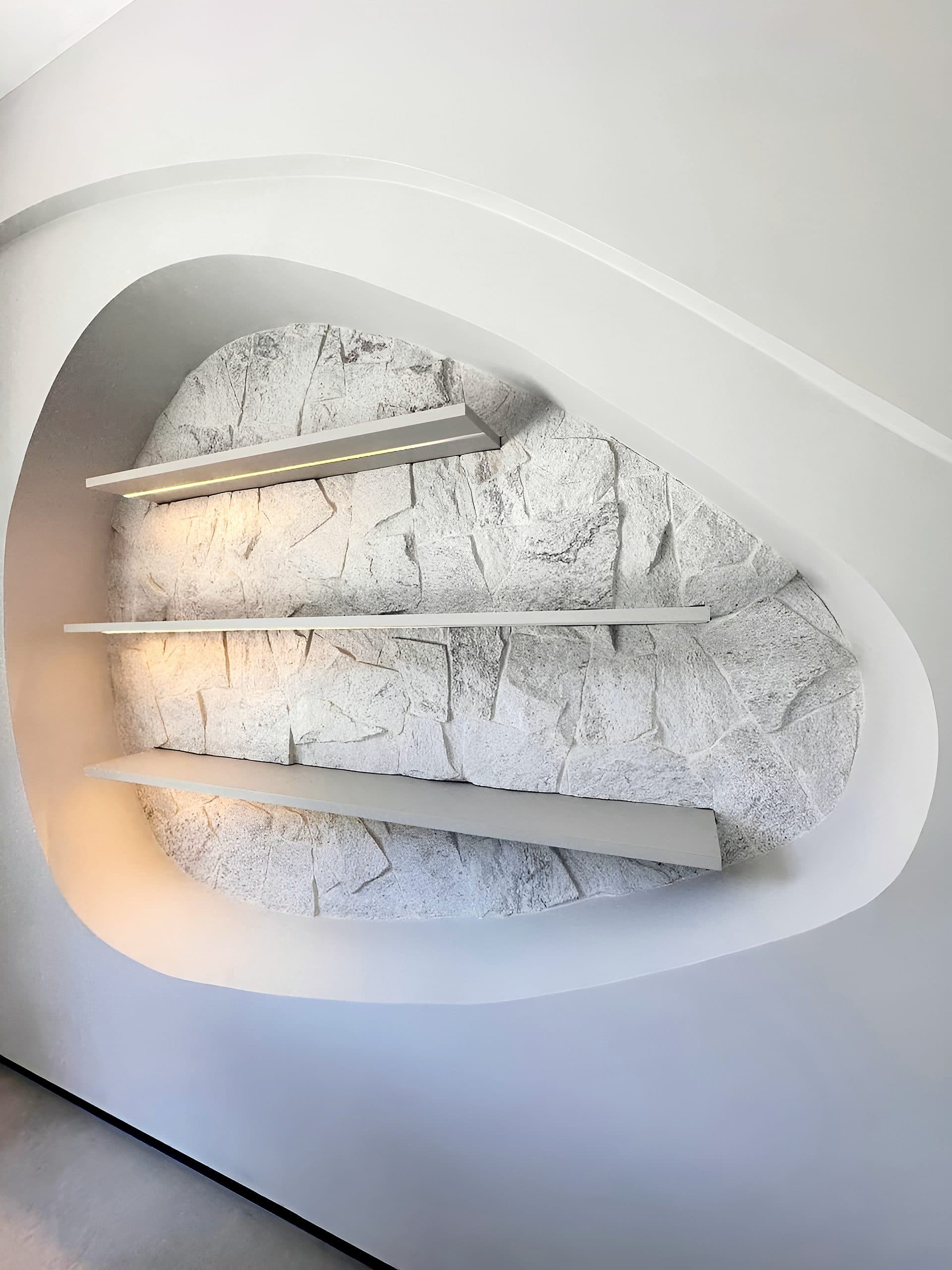 Hall com nicho orgânico iluminado em pedra e aparador sob medida — vista 3