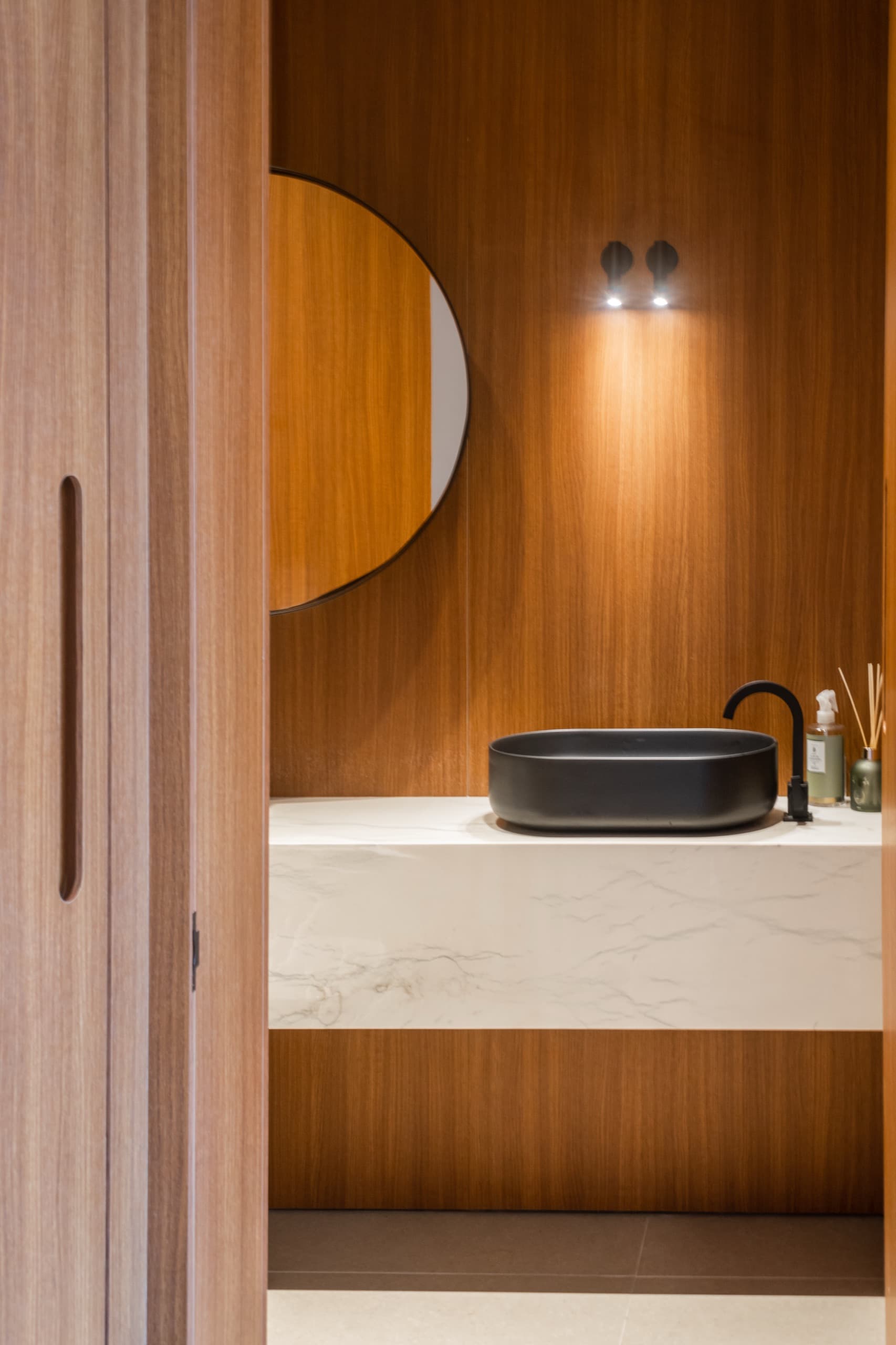 Lavabo com painel em madeira e bancada em pedra