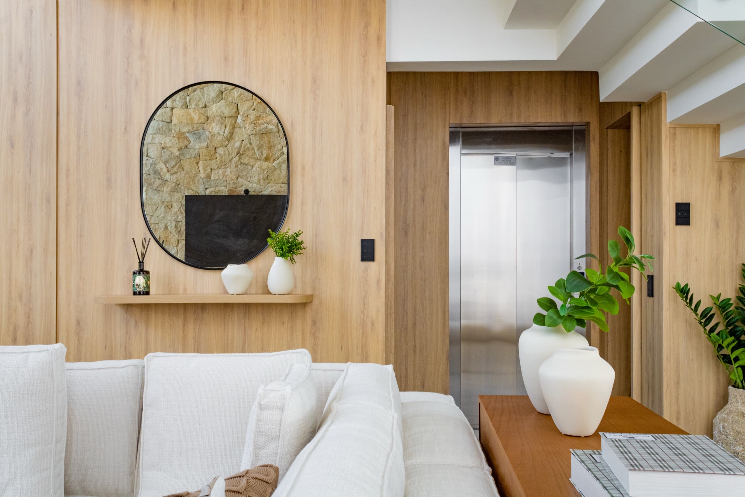 Living com escada e estar de mezanine ao fundo, marcenaria integrada