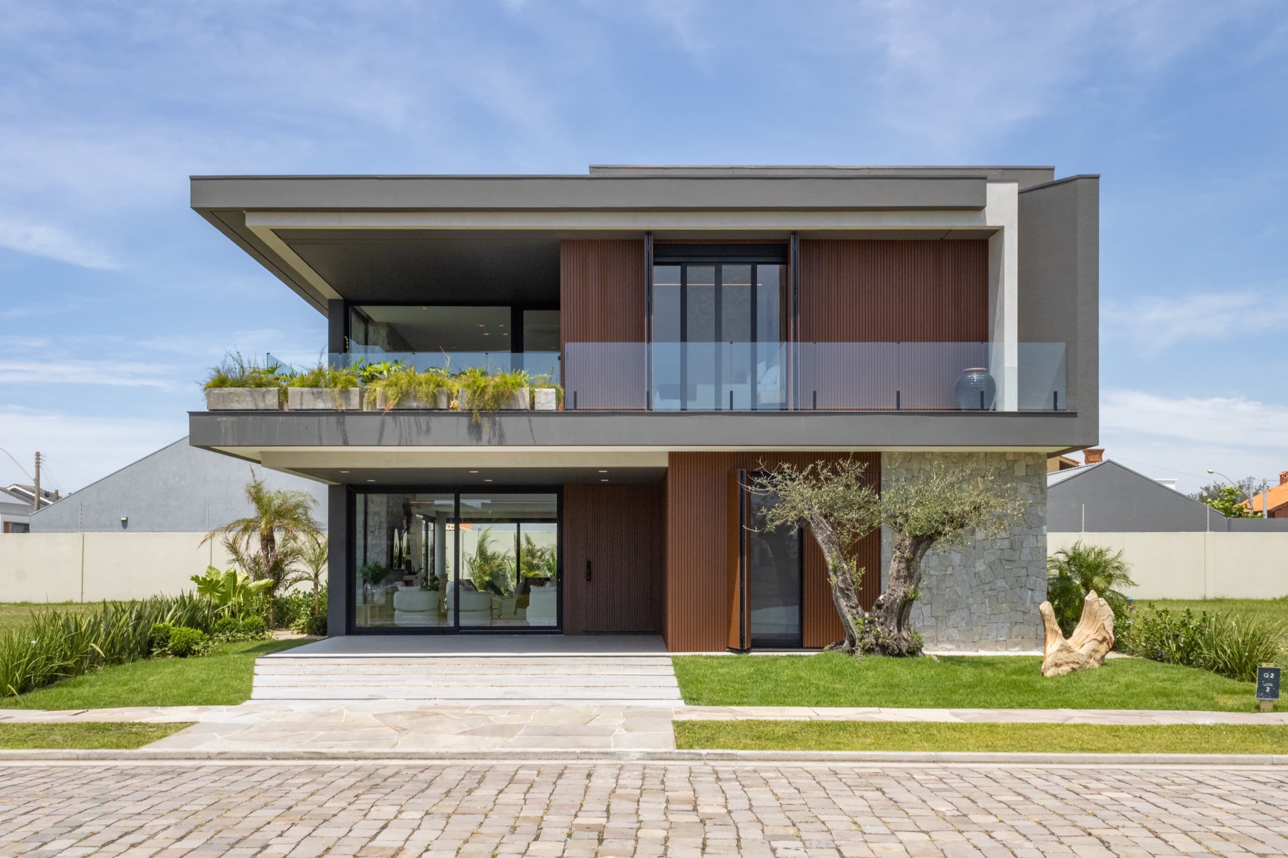 Fachada da casa com iluminação noturna e volumetria contemporânea