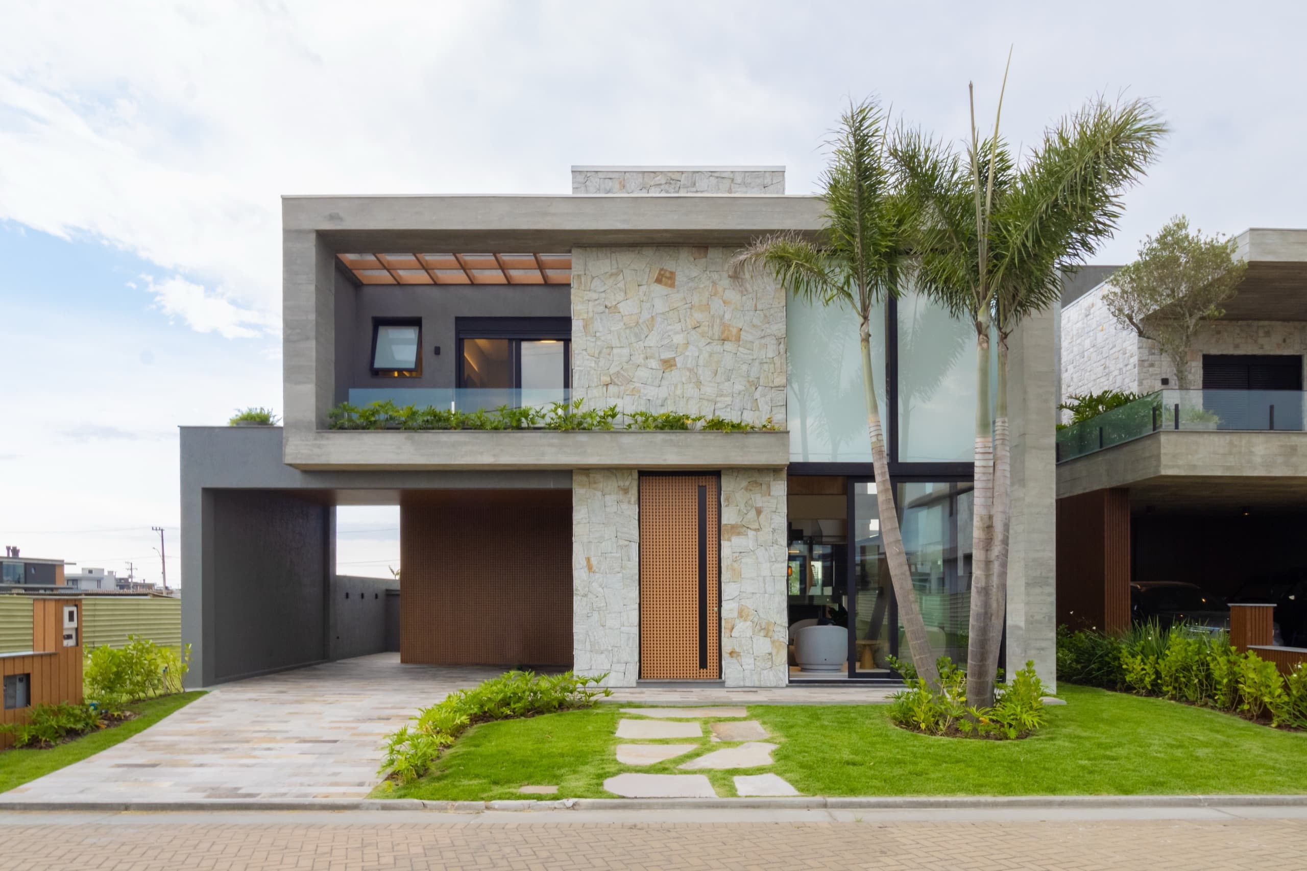 Fachada contemporânea com volumetria em concreto e madeira